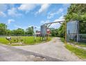 Gravel driveway entrance with decorative metal tanks and wooded surroundings at 1039 Forest Dr., Conway, SC 29526