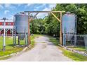View of a gravel driveway entrance with metal tanks and a peek of the house at 1039 Forest Dr., Conway, SC 29526