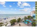 Gorgeous beach view shows a sandy beach, clear blue water, and an outdoor pool at 1105 S Ocean Blvd. # 520, Myrtle Beach, SC 29577