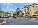Beautiful condo building exterior featuring tropical landscaping, palm trees, and ample parking at 135 S Dunes Dr. # 501, Pawleys Island, SC 29585