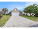 Inviting single-story home features a spacious driveway, lush green lawn, and mature landscaping, creating a welcoming curb appeal at 15 Saltwind Loop, Murrells Inlet, SC 29576