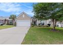 Attractive single-story home with a well-kept lawn, mature landscaping, and a long driveway leading to an attached two-car garage at 15 Saltwind Loop, Murrells Inlet, SC 29576