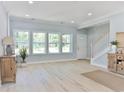 Sun-filled living room boasts hardwood floors, neutral paint, and a view of the staircase at 155 Mckenzie Circle, Pawleys Island, SC 29585