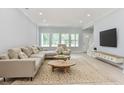 Relaxing living room featuring neutral-toned furniture, a large TV, and light hardwood floors at 155 Mckenzie Circle, Pawleys Island, SC 29585