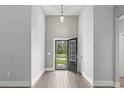 Bright foyer featuring an open front door, wood floors, neutral paint and stylish hanging light fixture at 1600 Palmetto Palm Dr., Myrtle Beach, SC 29579