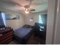 Small bedroom with a ceiling fan, a single bed, a desk with computer monitors, and dark curtains at 1903 Rose St., Conway, SC 29527