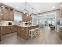 Open-concept kitchen with an island, seating, stainless appliances, and an adjacent dining and living area at 201 West Isle Of Palms Ave., Myrtle Beach, SC 29579