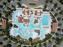 Aerial view of a community pool featuring a number of separate swimming areas with lounge chairs and manicured landscaping at 2205 Yellow Morel Way, Myrtle Beach, SC 29579