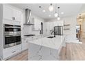 Modern kitchen with stainless steel appliances, a waterfall island, and white cabinets at 2205 Yellow Morel Way, Myrtle Beach, SC 29579