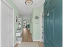 Bright entryway with hardwood floors, mint green walls, decorative mirror, and modern lighting fixture at 222 Landing Rd. # 1811, North Myrtle Beach, SC 29582