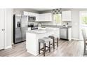Bright kitchen boasts white cabinets, stainless appliances, a granite island, and a stylish breakfast bar at 3210 Nw Edgemead Circle # C, Calabash, NC 28467