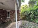 Side view of the spacious carport with brick walls, concrete floor and greenery at 41 Harmon St., Hemingway, SC 29554