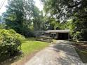 Quaint brick home featuring a convenient ramp, a driveway and surrounding trees at 41 Harmon St., Hemingway, SC 29554