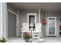 Inviting covered front porch featuring white Adirondack chairs with view, perfect for relaxing or enjoying your morning coffee at 4396 Baldwin Ave. # 1, Little River, SC 29566