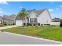 Charming single-story home with a lush green lawn and a neatly landscaped yard and palm tree at 462 Pacific Commons Dr., Surfside Beach, SC 29575