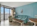 Living room with sofa, chair and table, access to balcony and ocean views at 4800 S Ocean Blvd. # 1221, North Myrtle Beach, SC 29582