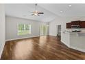 Bright open-plan living room with vaulted ceiling, hardwood floors, fan, and sliding doors leading to the outside at 5115 Huston Rd., Conway, SC 29526
