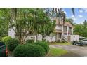 Serene condo exterior with mature trees, golf cart, and private entrance at 64 Bamboo Loop # 161, Georgetown, SC 29440