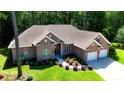 An aerial view captures this brick home with a two-car garage, complemented by its landscaped surroundings in a lush setting at 6572 Wellington Dr., Murrells Inlet, SC 29576