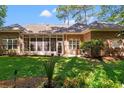 The backyard boasts a screened-in porch with a grill, perfect for outdoor dining and entertaining, set in a lush lawn at 6572 Wellington Dr., Murrells Inlet, SC 29576