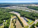 Extensive aerial perspective showcasing a vibrant community with tree-lined streets, scenic ponds, and modern homes at 776 Nw Palm Frond Way # 55, Calabash, NC 28467
