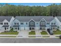 View of modern townhomes with garages, landscaped lawns, and dark-colored vehicles parked in driveways at 786 Nw Palm Frond Way # 51, Calabash, NC 28467