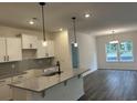 Modern kitchen features granite counters, pendant lighting, white cabinets, and stainless steel appliances at 122 Westfield Circle, Conway, SC 29526