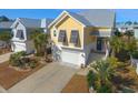 A vibrant yellow two-story home with a garage, neat landscaping, and dark shutters providing curb appeal at 148 Splendor Circle, Murrells Inlet, SC 29576
