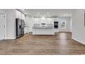 Bright, open-concept kitchen featuring white cabinetry, stainless steel appliances, and wood-look flooring at 1529 Bucksport Rd., Conway, SC 29527