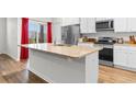 Bright kitchen featuring a center island with a sink, granite countertops, stainless steel appliances, and ample cabinetry at 1704 Perthshire Loop, Myrtle Beach, SC 29579