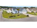 Well-manicured lawn surrounds the light blue home with a palm tree and white fencing at 252 Heath Dr., Longs, SC 29568