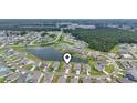 Aerial view of homes in a lakeside community surrounded by a lush green forest at 3078 Gillham Loop, Myrtle Beach, SC 29588