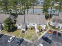 An aerial view of a condo building nestled among trees, near a tranquil lake and ample parking at 4486 Little River Inn Ln. # 2103, Little River, SC 29566