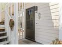 Charming front door with welcome sign, located at 2103, on a light-colored home at 4486 Little River Inn Ln. # 2103, Little River, SC 29566