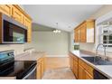 Well-lit kitchen with tan counters, stainless steel appliances, and oak cabinets at 520 Winged Elm St., Loris, SC 29569