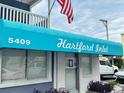 Close-up of a building entrance under a blue awning with the name 'Hartford Inlet' and building number at 5409 N Ocean Blvd. # 111, North Myrtle Beach, SC 29582