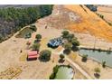 Stunning aerial view of a property featuring multiple ponds, a red barn, and vast open fields at 589 Loop Circle, Longs, SC 29568