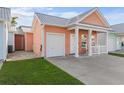 Inviting peach home boasts a metal roof, a cute front porch, and convenient garage at 603 Wave Rider Ln. # 603, North Myrtle Beach, SC 29582