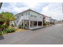 Charming raised beach home with stairs, white railings, and a carport on the ground level at 820 9Th Ave. S, North Myrtle Beach, SC 29582