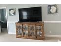 Living room featuring a rustic wood cabinet with glass doors and nautical decorations displayed on a TV console at 1029 Ray Costin Way # Villa 909, Murrells Inlet, SC 29576