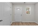 Bright entryway with wood-look floors, white trim, a white door with glass, and a window letting in natural light at 1064 Oak Meadow Dr., Conway, SC 29526