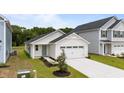Attractive home with a two-car garage, landscaped front yard, and pleasant light green front door at 1064 Oak Meadow Dr., Conway, SC 29526