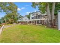 Expansive backyard with manicured lawn, a patio area, and serene views of the waterfront at 1080 Waterway Ln., Myrtle Beach, SC 29572