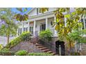 Elegant exterior featuring white columns and brick stairs, framed by lush greenery under a bright sky at 1080 Waterway Ln., Myrtle Beach, SC 29572