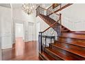Grand foyer with hardwood floors, staircase with iron railing, and elegant chandelier at 1080 Waterway Ln., Myrtle Beach, SC 29572