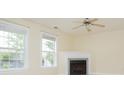 Cozy living room with a fireplace, ceiling fan, and plenty of natural light from two windows at 112 Molinia Dr., Murrells Inlet, SC 29576