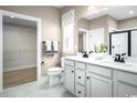 Bathroom with double sink vanity, neutral color palette, and a walk in closet at 1308 Piper Glen Dr, Sunset Beach, NC 28468