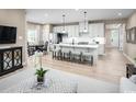 Bright, open-concept kitchen features stainless steel appliances, a center island with seating, and hardwood floors at 1308 Piper Glen Dr, Sunset Beach, NC 28468
