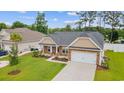 Lovely single-story home with manicured lawn, landscaping, and an attached two-car garage at 131 Crabapple Dr., Longs, SC 29568
