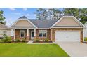 Charming brick home featuring well-maintained landscaping and an attached two-car garage at 131 Crabapple Dr., Longs, SC 29568